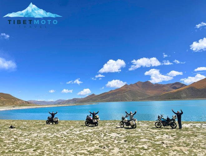 Four motorcyclists in front of Pangong Lake in Tibet.