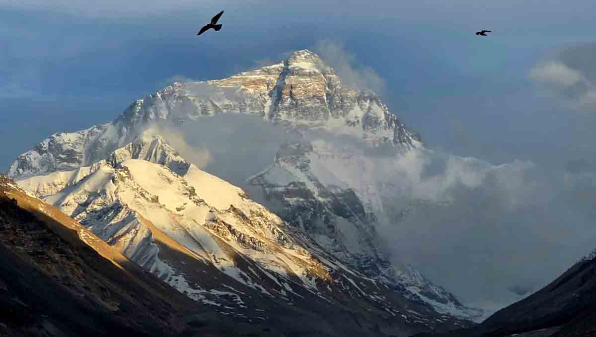 mount everest north face at sunset tibet Mount Everest illuminated by soft evening light as clouds drift across the summit from the Tibetan side.